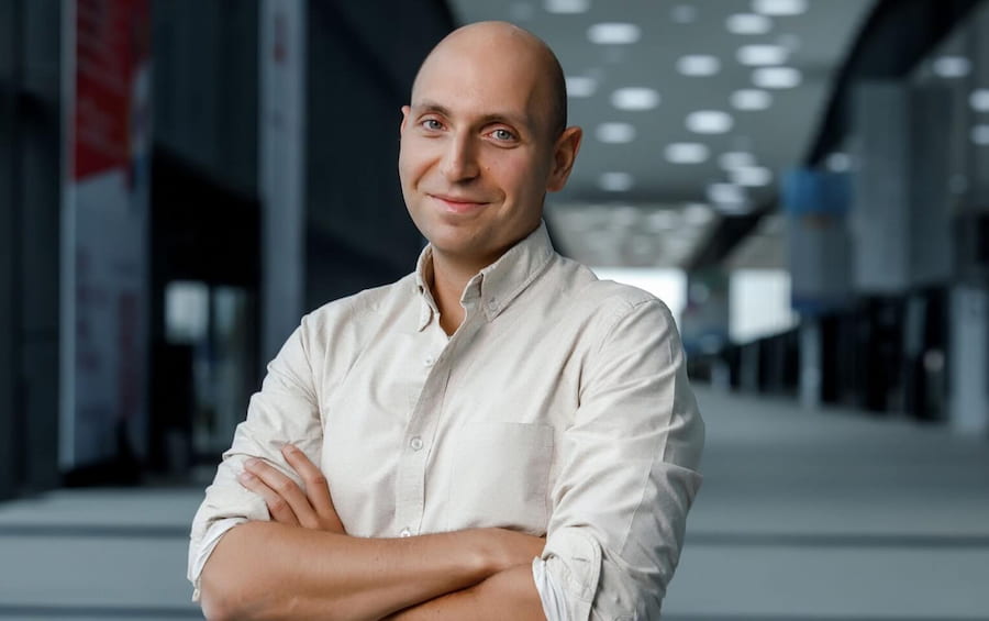 Vitaly sitting at a computer desk with a cup of coffee